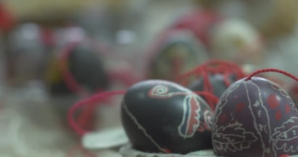 Huevos de Pascua pintados con cordones rojos La mano de la mujer Los coloridos huevos pintados cuelgan de los cordones rojos La tecnología de la pintura en el huevo de Pascua — Vídeo de stock