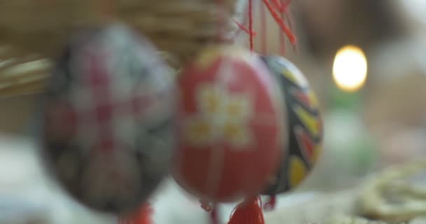 Dos chicas dibujan en los huevos de Pascua en primer plano coloridos huevos pintados cuelgan de los cordones rojos Tecnología de pintura en el huevo de Pascua por el boceto — Vídeos de Stock