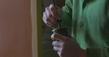 Ressam sanatçı adam elinde yeşil elleri yakın kadar Kupası kapalı gün ışık fırça ile boya karıştırma