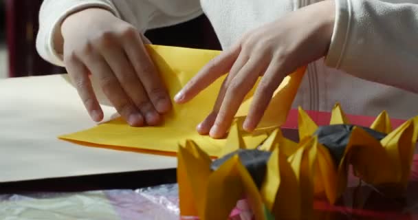 Kind maakt zonnebloem van gekleurd papier twee papier zonnebloemen op tabel Origami wedstrijd maken van Kusudama assembleren van modulaire Origami eenheid Origami sluiten — Stockvideo