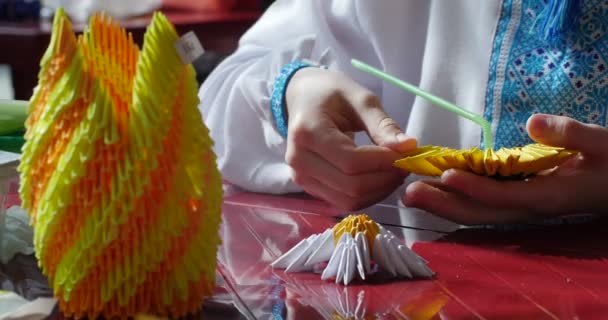 Junge in blau-weiß vyshyvanka macht Sonnenblume aus Papier Kinder machen Origami aus geklontem Papier Origami Wettbewerb Herstellung von kusudama montieren von modularen Origami — Stockvideo