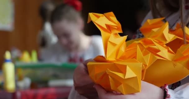 Girl In Vyshyvanka Makes Origami From Orange Paper Kids Make Origami Origami Contest Making Of Kusudama Assemble Of Modular Origami Unit Origami Cerrar — Vídeo de stock