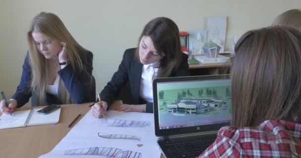 Két lány írhat és rajzolhat lány órák képek egy Laptop hallgatók kar építészet tanterem építészeti vázlatok rajzok minták sematikus — Stock videók