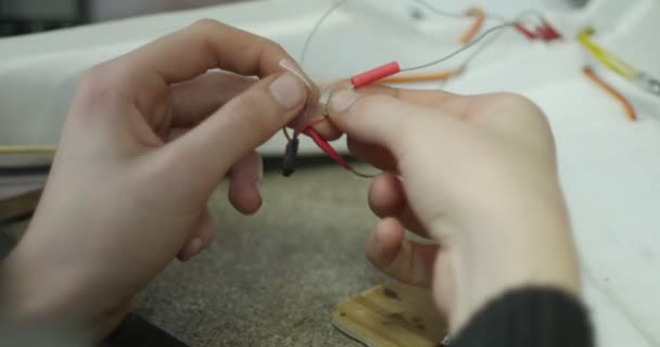 Hombre desenreda manos cables que están en la mesa especialista en trabajo — Vídeos de Stock