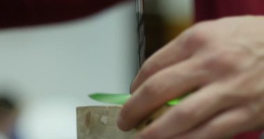 adam bir parlak yeşil parça drill bit delik delme getiriyor.