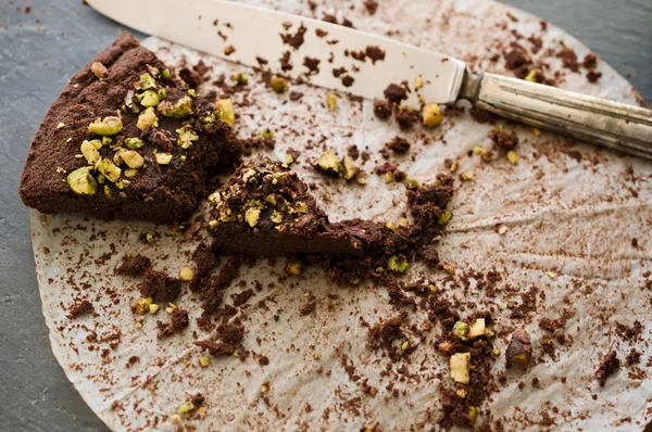 Crumbling last piece dark chocolate and pistachio cake — Stock Photo, Image