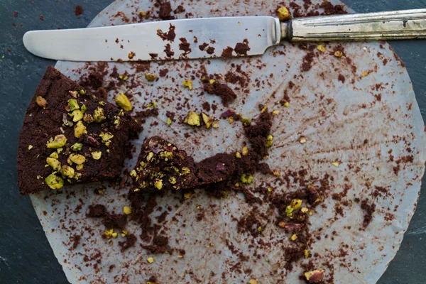 Crumbling last piece dark chocolate and pistachio cake — Stock Photo, Image