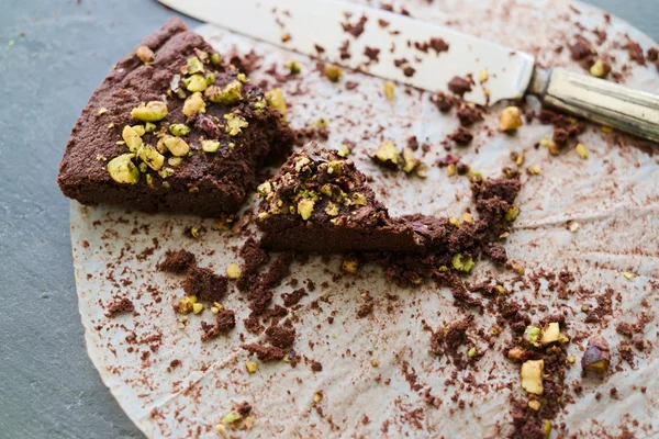 Crumbling last piece dark chocolate and pistachio cake — Stock Photo, Image