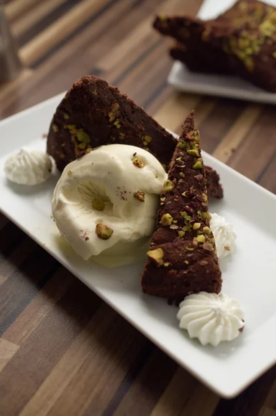 Dark chocolate and pistachio ice cream cake in restaurant settin — Stock Photo, Image