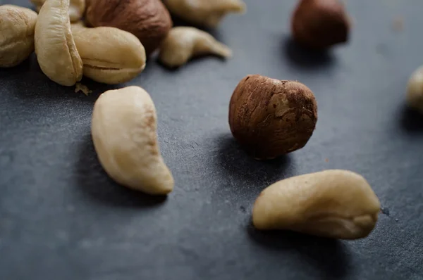 Karışık kaju ve koyu arka plan üzerinde ela fındık