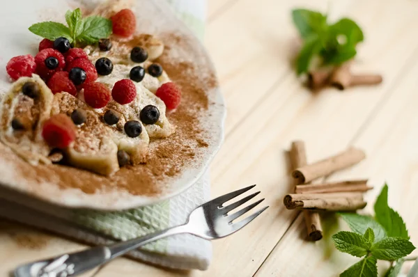 Sweet dessert fresh cottage cheese filled dumpling rolls with blueberries, raspberries and powdered cinnamon — ストック写真