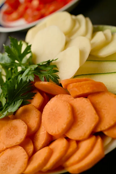 Dilimlenmiş sebze ve otlar havuç, patates, domates ve maydanoz