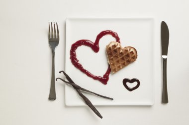 Heart shaped waffles, marmalade, chocolate sauce, vanilla sticks clipart