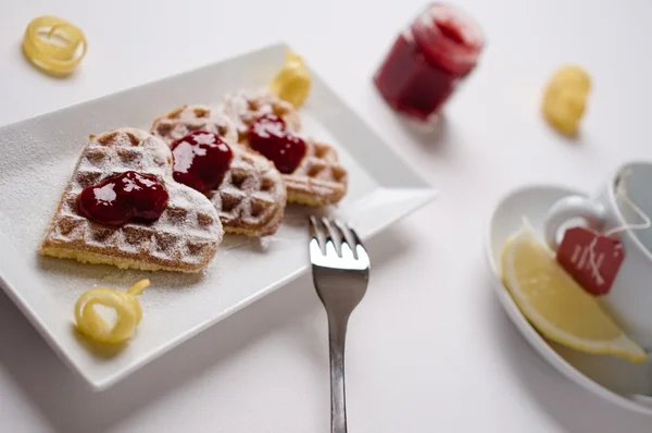 Heart waffles, jam, powdered sugar served on rectangular plate — 스톡 사진