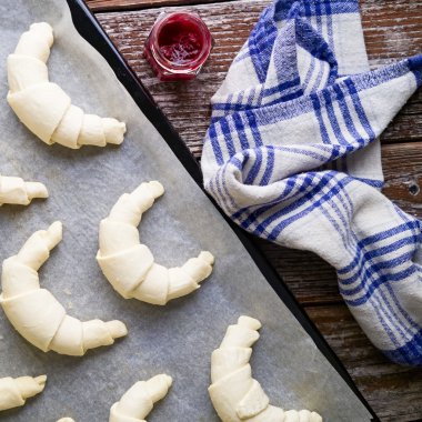 Homemade croissants filled with berry marmalade jam on rustic ta