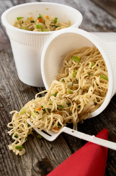 Instant noodles pasta ramen spilled on rustic wood table