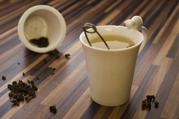 Yeşil çay üzerinde ahşap masa temiz bir şekilde dekore edilmiş çay Kupası