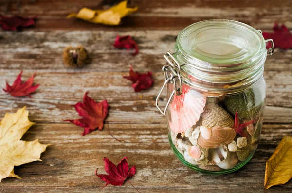 Concept of changing seasons summer in jar in rustic setting