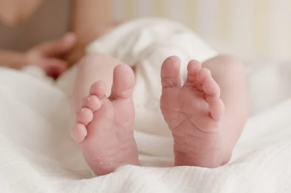 Newborn baby feet on white cloth diaper horizontal
