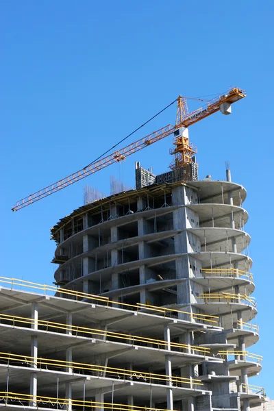 Mavi gökyüzüne karşı vinç ve inşaat alanı