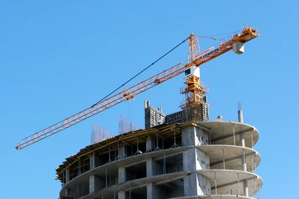 Mavi gökyüzüne karşı vinç ve inşaat alanı