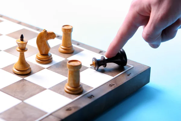 Närbild av mänsklig hand kraschar svart chess king — Stockfoto