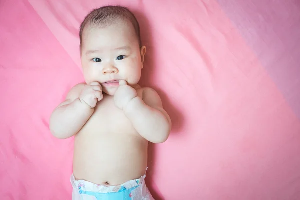 Asiatische baby Mädchen auf rosa Bett — Stockfoto