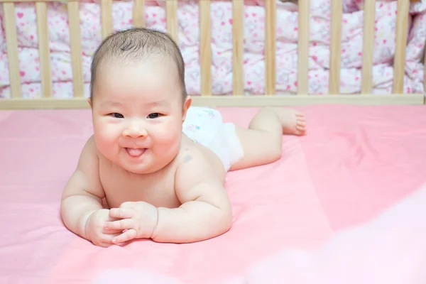 Asijské dítě dívka zamračil na růžové posteli — Stock fotografie