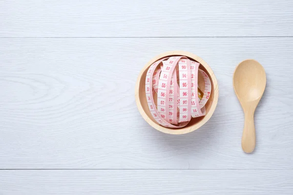 Tape Measure in wooden bowl — Stock Photo, Image