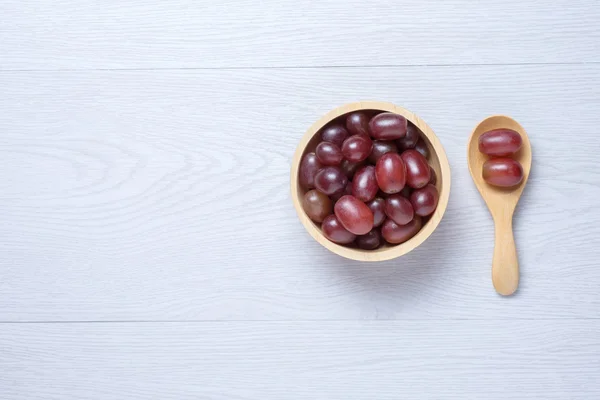 Red grapes in wooden bowl and spoon — Stock Photo, Image