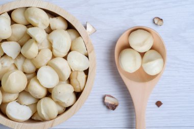 Üstten Görünüm macadamia fındık ve ahşap kase içinde deniz hayvanı kabuğu