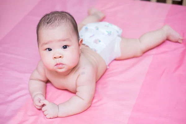 Asiatico bambino ragazza scowl su rosa letto — Foto Stock