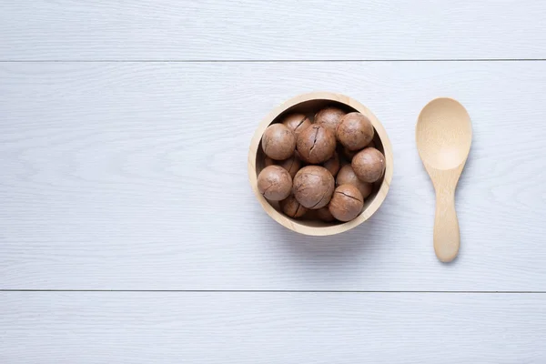 Üstten Görünüm macadamia Beyaz ahşap masa üzerinde ahşap kase
