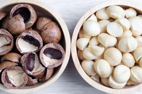 Üstten Görünüm macadamia fındık ve ahşap kase içinde deniz hayvanı kabuğu