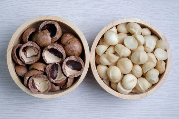 Üstten Görünüm macadamia fındık ve ahşap kase içinde deniz hayvanı kabuğu