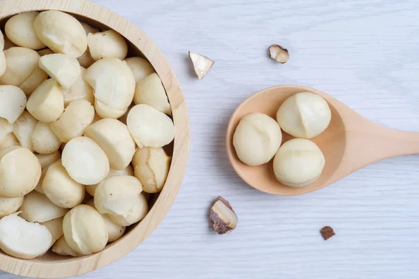Üstten Görünüm macadamia fındık ve ahşap kase içinde deniz hayvanı kabuğu