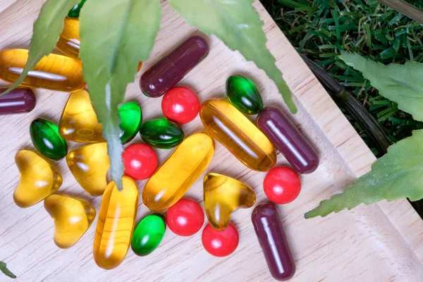 Medicina y vitamina en plato de madera —  Fotos de Stock