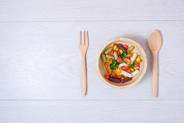 Tıp ve vitamin üzerinde ahşap kase