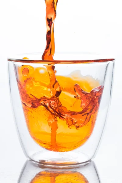 Oranje water gieten in glas wissen — Stockfoto