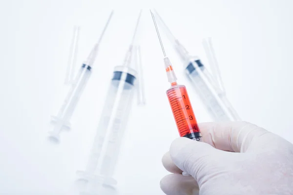 Hand holding red vaccine syringe — Stock Photo, Image