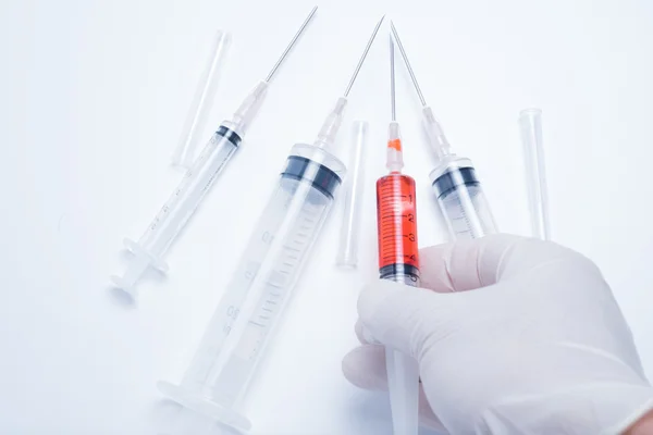 Hand holding red vaccine syringe — Stock Photo, Image