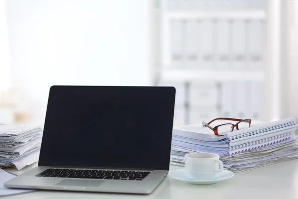 Laptop mit Ordnerstapel auf Tisch auf weißem Hintergrund — Stockfoto