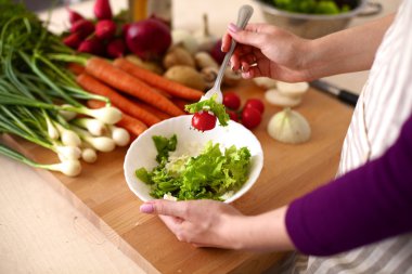Genç kadın mutfakta yemek pişiriyor. Sağlıklı Yemek