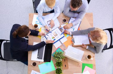 İş ortaklarının toplantıda belge ve fikirleri tartıştığı resim