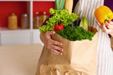 Çeşitli meyve ve sebze kahverengi bakkal çantada bir genç kız