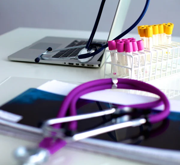 medical stethoscope on a computer, and test tubes