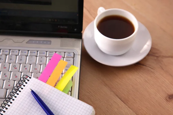 Mesa de escritório com bloco de notas em branco e laptop — Fotografia de Stock