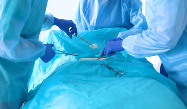 Equipe de cirurgião em uniforme realizar operação em um paciente na clínica de cirurgia cardíaca — Fotografia de Stock