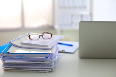 Beyaz arkaplanda dizin yığını olan dizüstü bilgisayar