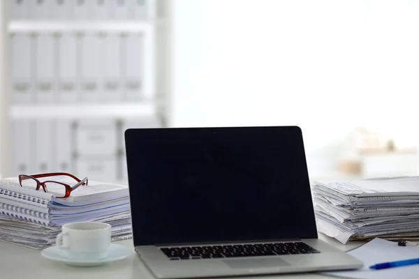 Laptop mit Ordnerstapel auf Tisch auf weißem Hintergrund — Stockfoto